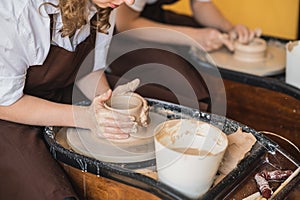 The manufacture of ceramics. Two woman prepare clay for work on pottery wheel. Close up view of hands.