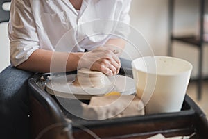 The manufacture of ceramics. Woman prepare clay for work on pottery wheel. Close up view of hands.