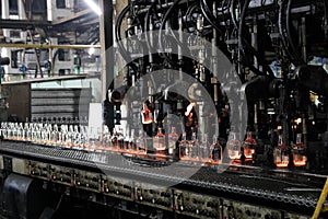Manufacture of glass products, machine produces hot bottles by means of metal molds for blowing and pressing hot glass