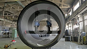 Manufacture of plastic water pipes. View of the factory floor. Finished large pipe. The process of making plastic pipes