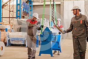 Manufacture workshop. move the crane with beam. Workers adjusts the machine in the warehouse. the production of
