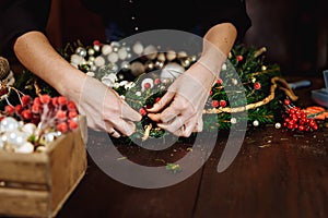 Young Cute smiling Woman designer preparing Christmas Evergreen Tree Wreath. Manufacturer of Christmas decor with their