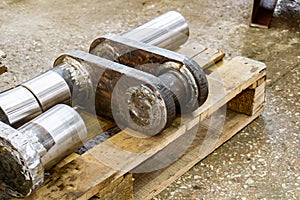 After manufacturing, the industrial crankshaft rests on the rack in the warehouse