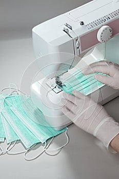 Manufacturing process of medical protective masks on sewing machine by worker in gloves