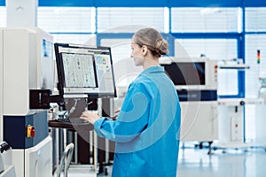 Manufacturing worker checking data of assembly line on screen