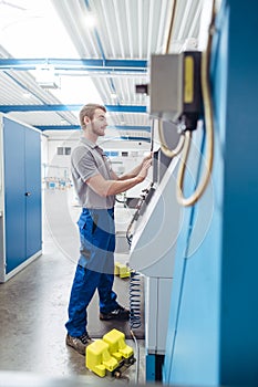 Manufacturing worker programming industrial CNC machine tool