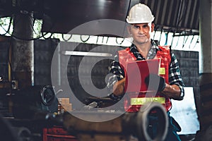 Manufacturing worker working with clipboard to do job procedure checklist .