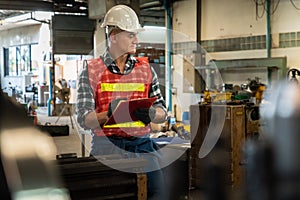 Manufacturing worker working with clipboard to do job procedure checklist .