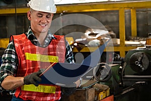 Manufacturing worker working with clipboard to do job procedure checklist .