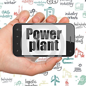 Manufacuring concept: Hand Holding Smartphone with Power Plant on display