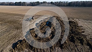 Manure pile on the field. Spring field work. Aerial survey