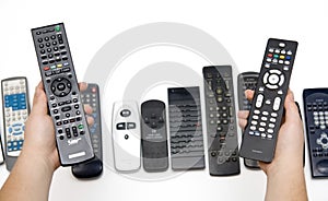 Many Assorted Remote Controls in Hands