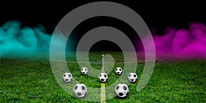 Many balls in textured soccer game field with neon fog - center position, midfield at night. Panorama