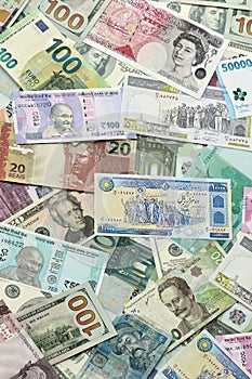 Many banknotes of different currency. Background of big amount of random money bills