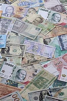 Many banknotes of different currency. Background of big amount of random money bills