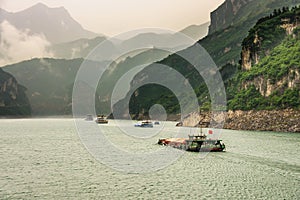 Many barges sailing upriver Yangtze River West of 3 Gorges Dam, Zigui, China