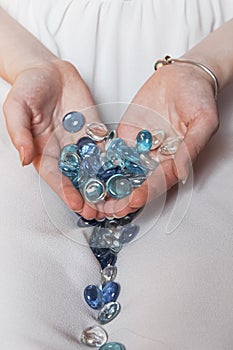 Many beautiful beads in the hands of a girl