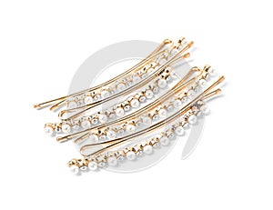 Many beautiful gold hair pins with gems on background