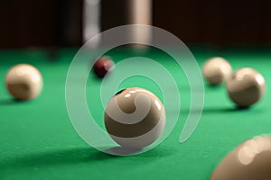 Many billiard balls on green table indoors, closeup