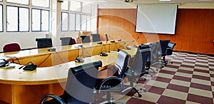 Many black chair, microphone and white monitor inside meeting room