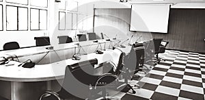 Many black chair, microphone and white monitor inside meeting room in black and white style