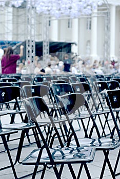 Many black plastic chairs in many rows. Preparation for the concert