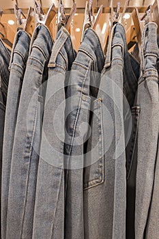 Many blue jeans on the rack in shop for sale