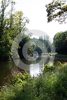 Many boats plying the river under the mid-afternoon sun in France