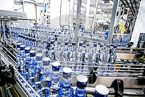 Many bottles of alcohol on assembly line on factory