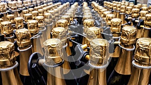 Many bottles of champagne with gold foiled bottleneck and anti-theft systems in store. Front view