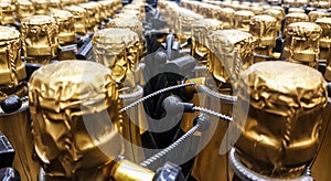 Many bottles of champagne with gold foiled bottleneck and anti-theft systems in store. Front view