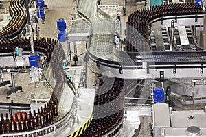 Many bottles on conveyor belt in factory