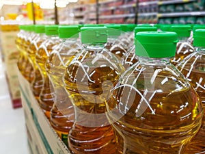 many bottles in row stack of vegetable oil on the shelves in supermarket material for making the healthy food for good health