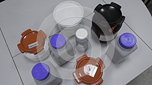 Many bottles of solvents and reagents for cell culture on a shelf in laboratory