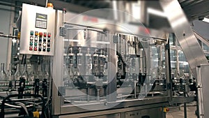 Many bottles of vodka or gin on conveyor belt in factory. Bottling plant