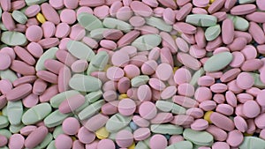 Many brightly multi-colored antibiotic medication antibiotic pills move close-up