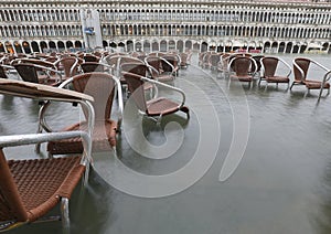 many brown chairs on the water during the record high tide in Ve photo