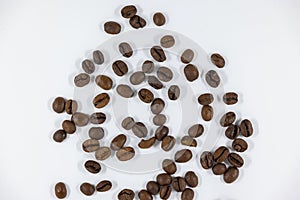Many brown coffee beans photographed from above against white background, studio shot, caffeinated soaked
