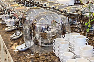 Many buffet dishes that are lined up serve customers.