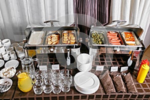 Many buffet heated trays ready for service. Breakfast in hotel catering buffet, metal containers with warm meals