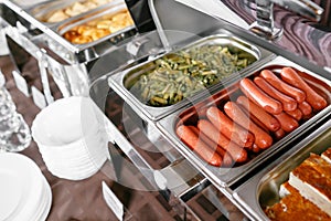 Many buffet heated trays ready for service. Breakfast in hotel catering buffet, metal containers with warm meals