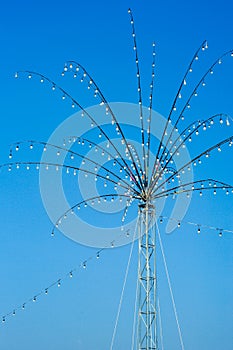 Many bulbs decorated on the steel branches in the shape of flower for local festival in Thailand isolated on blue sky background