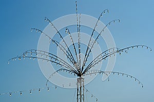Many bulbs decorated on the steel branches in the shape of flower for local festival in Thailand isolated on blue sky background