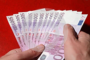 Many bundle of 500 Euro bank notes in man's hands