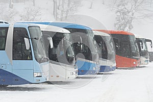 Many buses are parking at yard during heavy snowing