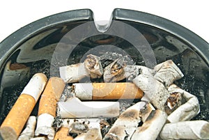 Many butts in black ashtray
