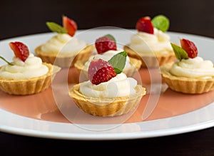 Many cakes, cupcakes with fresh fruits (strawberries), whipped cream, jelly and mints