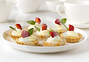 Many cakes or mini tart with fresh fruits, whipped cream and mints