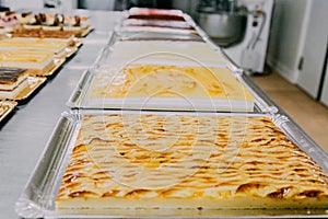 Many cakes prepared on the metal table of a food factory