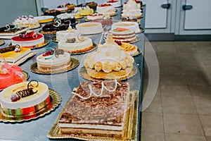 Many cakes prepared on the metal table of a food factory